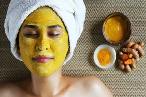 woman with a facial mask of turmeric
