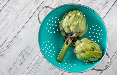 two whole artichokes in bowl