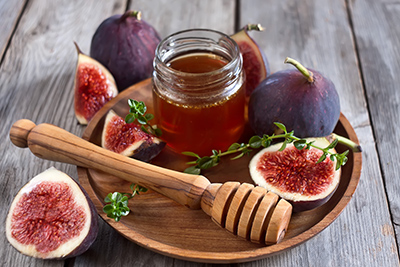 figs on plate with jar of honey