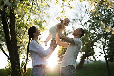 mother and father holding up baby