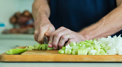 someone chopping celery on a cutting board