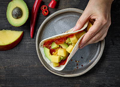 hand holding a corn tortilla