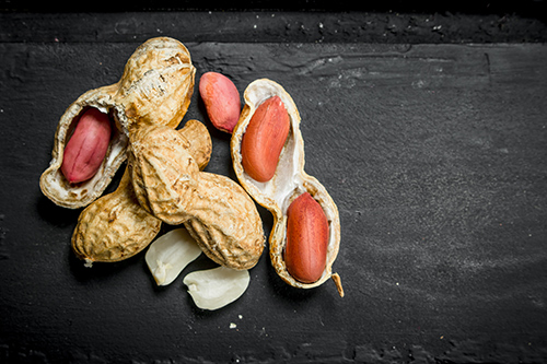 cracked and uncracked peanuts on a black background