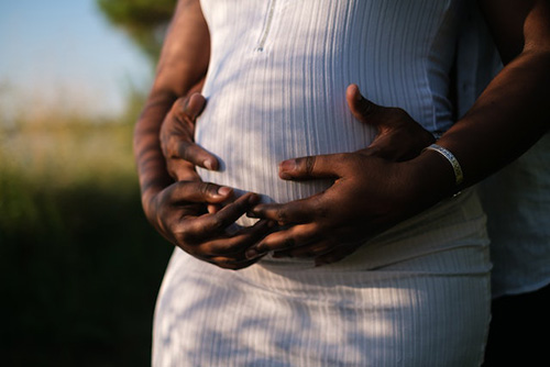pregnant woman and her husband holding her stomach