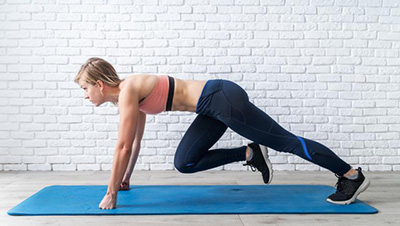 woman doing mountain climber ab exercises on a yoga mat