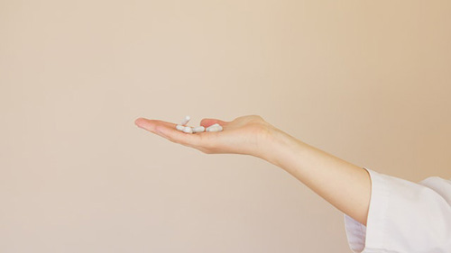 woman holding her hand filled with two types of diabetic medication