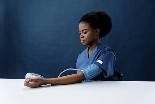 woman taking blood pressure reading with monitor