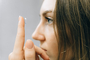 woman with contact lens on her finger