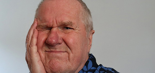 man with hand on jaw because of toothache