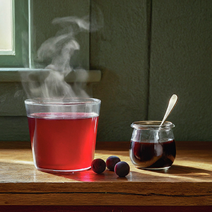 cup of tea and bottle of prunus spinosa syrup