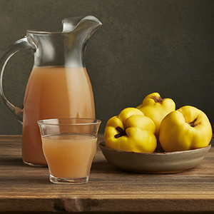 glass and pitcher of quince fruit juice