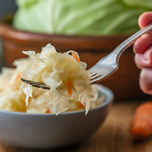 Someone holding a fork filled with sauerkraut